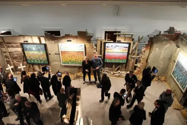 Crowd viewing Marc Marot and Scarlett Raven's flower field paintings in a ruined-wall exhibition set, many holding tablets