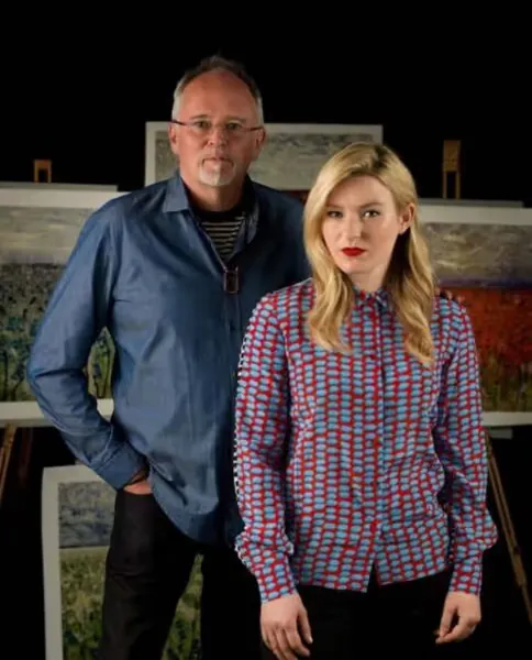 Marc Marot and Scarlett Raven standing in front of easels with their paintings