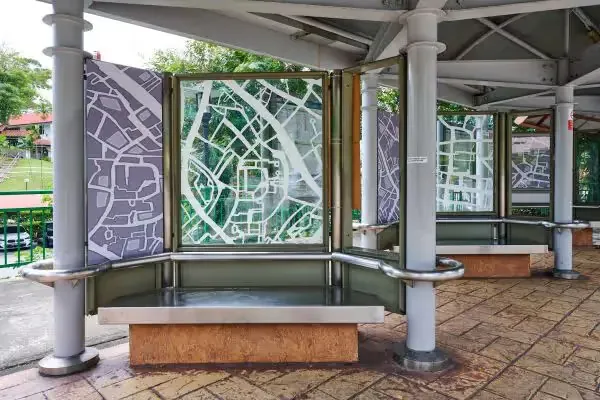 Covered seating area with glass panels printed with white street map artwork by Andy Yang