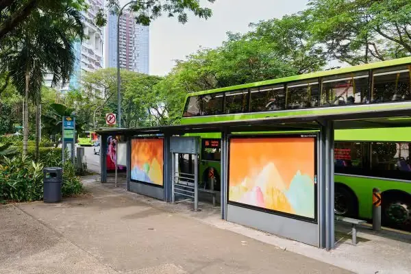 Bus stop with pastel landscape artwork panels by Andy Yang and a green double-decker bus