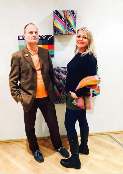 Elisa Rose and Gary Danner of Station Rose standing in front of their colorful geometric artworks
