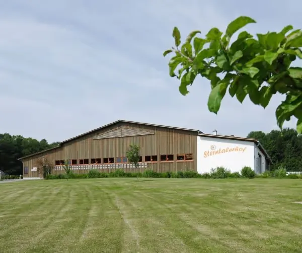 The Sterntalerhof children's hospice building, a long wooden barn-like structure behind a lawn