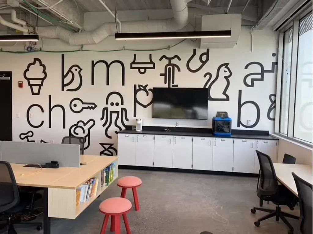 Renee Seward Nettle's black and white literacy mural of letters and icons like a cat, key and octopus in a research lab
